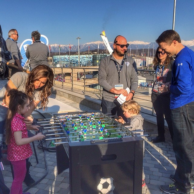 Silver medalist Noelle Pikus-Pace helps mic up her kids during a backstage game of foosball - can't get enough of this family! #SochiTODAY #Sochi2014